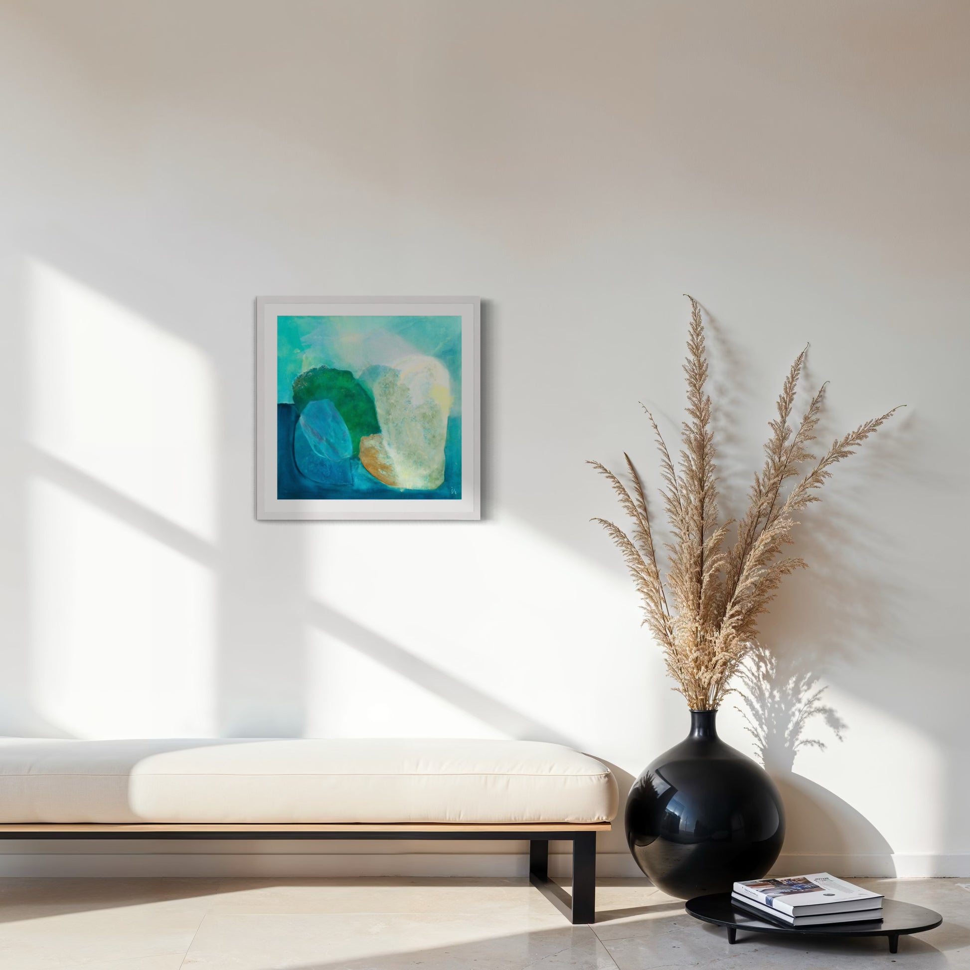 Gems, Abstract Fine Art Print on Paper with a classic frame of sustainable sourced wood painted in white. This artwork has nature inspired abstract shapes with playful movements in blue, emerald green, white, burnt orange. Hanging on a white wall above a bench with a large black vase on the floor next to it. Ingeborg Andersson Art