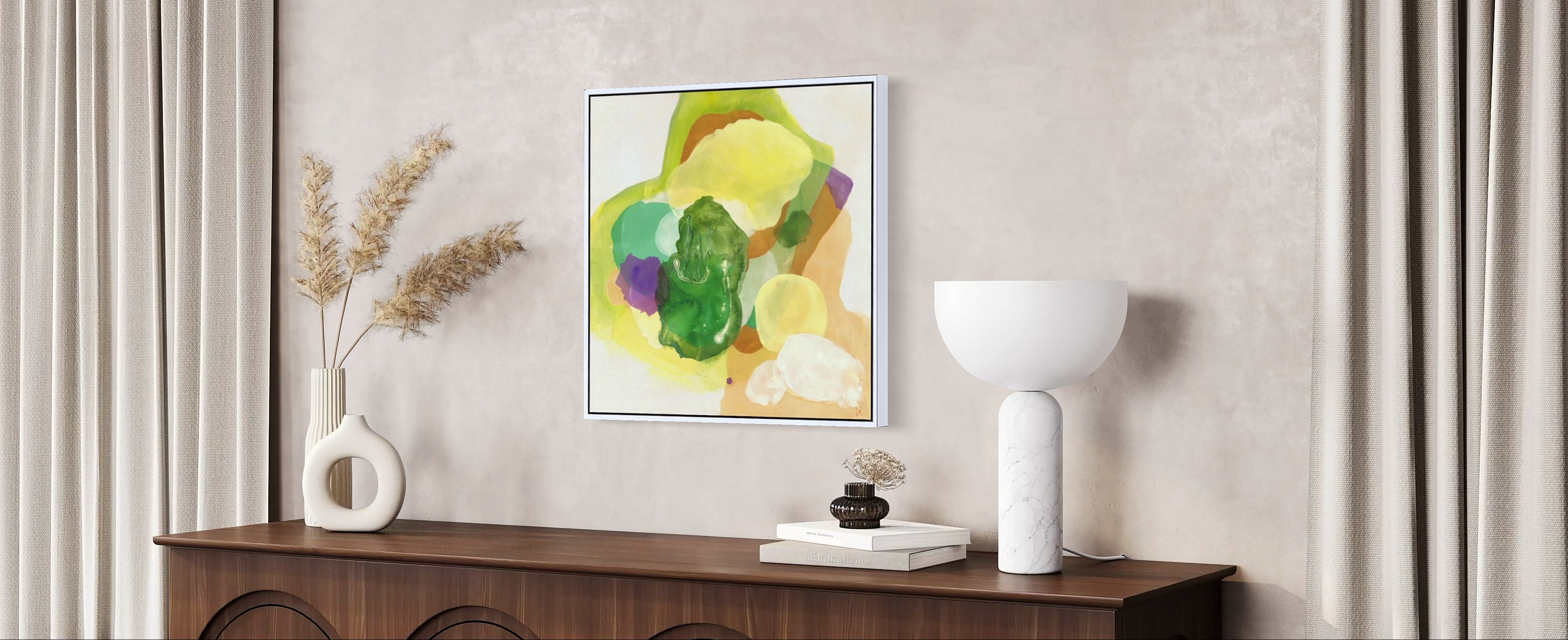 The Frog, abstract fine art print on canvas in a white floating frame of sustainable sourced wood. This artwork has nature inspired abstract shapes with playful movements in  green, white, violet, sand tones, yellow-greenish. Hanging in a modern living room, on a bright wall, a dark wood cabinet beneath with a plant, some sculptural vases, books and a modern white table lamp. Beside - long soft creme coloured curtains. Ingeborg Andersson Art