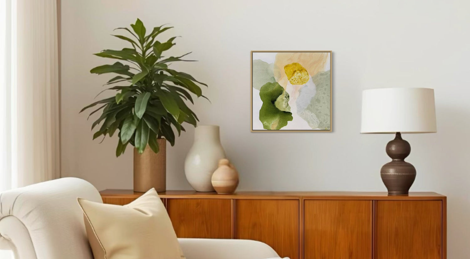 Yellow Diamond, abstract art framed in oak. Hanging on a wall  above a wooden cabinet in teak with a table and ceramic vases on top. A bright day sofa infront. A grreen plant. A living room in a Mid Century style. Ingeborg Andersson Art